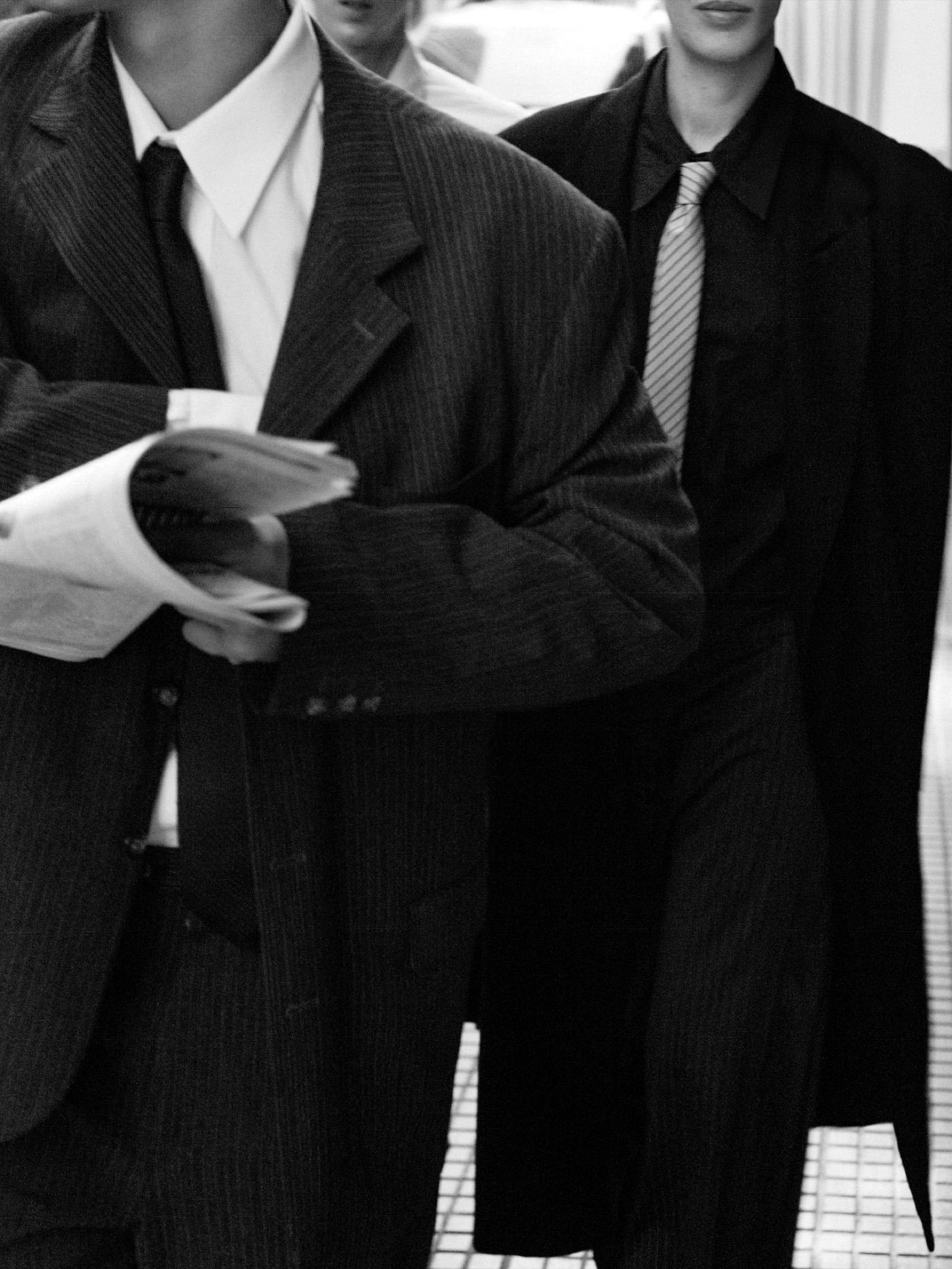 Dos personas de traje caminando por la calle