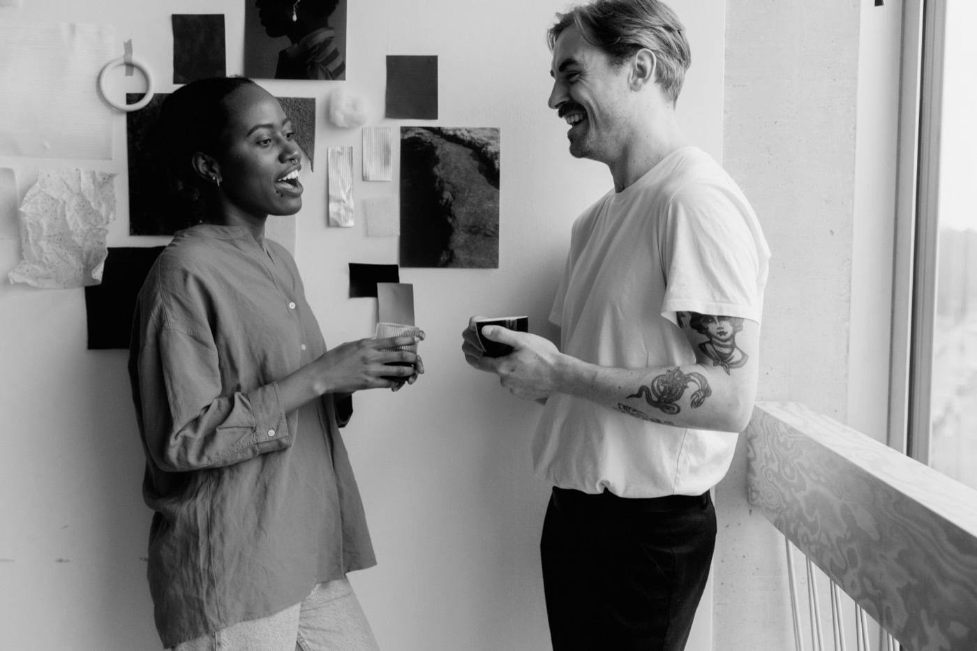 Dos personas conversando de pie con tazas en la mano